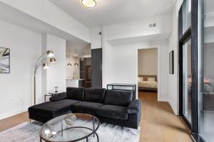 亚特兰大Midtown Luxury Apartment的客厅配有黑色沙发和玻璃桌