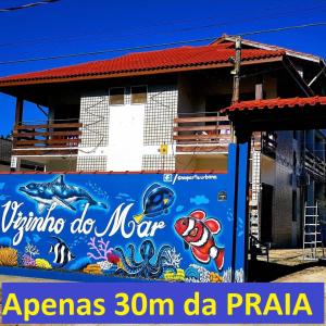 乌巴图巴Recanto Vizinho do Mar的建筑一侧的标志,上面有海洋广告