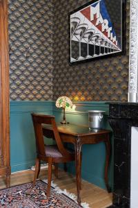 兰斯Demeure Belle Epoque的墙上的房间里一张桌子和一把椅子