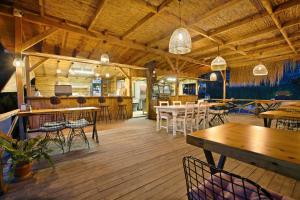法拉尔雅卡巴克查卡拉海滩酒店的餐厅铺有木地板,配有桌椅