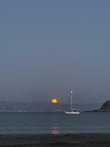 莫罗斯帕罗Molos Sea View House - Paros Greece的水中帆船,月亮在后方