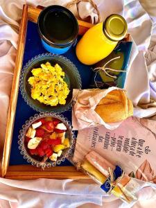 马卡埃Pousada Lazúli的包括鸡蛋和烤面包的早餐的食品托盘