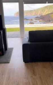 莫什泰鲁什Serenity Villa - Azorean Butler的带沙发的客厅,享有海景