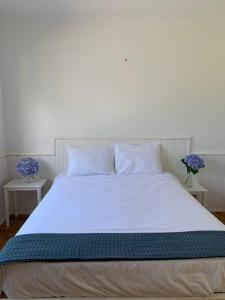 莫什泰鲁什Serenity Villa - Azorean Butler的一张带白色床单和枕头的床