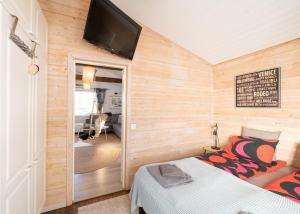 波里Villa Einola- modern rivercottage with jacuzzi的客房设有一张床和一台平面电视。
