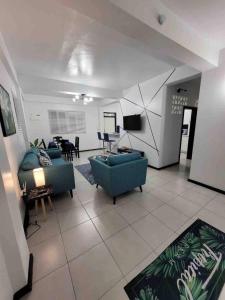格罗斯岛Chalet Belizomi Tropical Villa #1的客厅配有2张蓝色沙发和电视