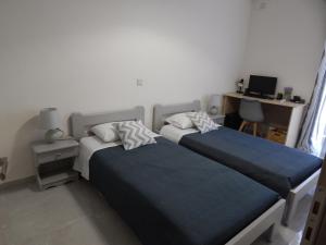 扎金索斯镇Vera City Apartment的一间卧室配有两张床和一张带电脑的书桌