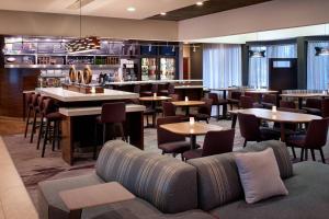 罗缪勒斯底特律都会机场罗穆卢斯万怡酒店的一间带桌椅的餐厅和一间酒吧