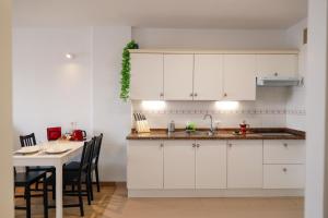 巴哈马尔Apartamento Maye的厨房配有白色橱柜和桌椅