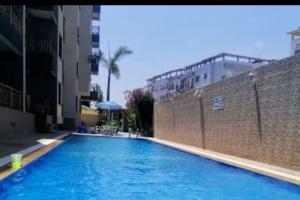 杰迪代Appartement avec piscine proche de Sidi Bouzid的砖墙旁边的大型蓝色游泳池