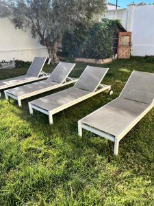 马尼尔瓦Villa Duquesa的草地上摆放着四把躺椅