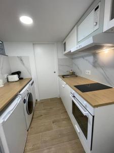 巴约讷MiniLoft #Baiona /的厨房配有白色橱柜、洗衣机和烘干机