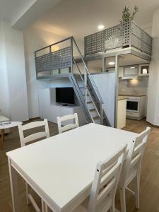 巴约讷MiniLoft #Baiona /的一间设有白色桌椅和楼梯的房间