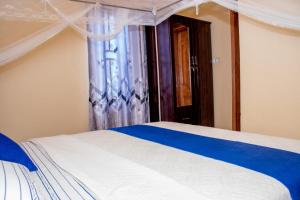 布琼布拉B I G Residence Hotel的一间卧室设有一张床和一个窗口