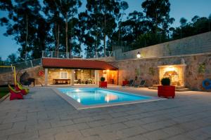 蓬德利马Casa do Sabugueiro的一座带房子的庭院内的游泳池