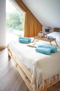 JoniecOsada Joniec的一间卧室配有一张带蓝色枕头的床和一扇窗户。
