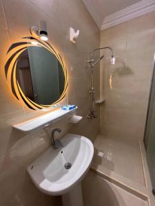 埃兹贝特Pyramids Desert Gate Hotel的一间带水槽、镜子和淋浴的浴室
