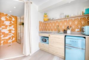 圣胡安HOUS - Ocean Park - Pool - Sunset Lounge的厨房配有木制橱柜和蓝色的洗碗机。
