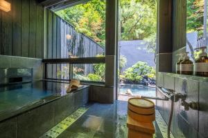 上田市Bessho Onsen Midoriya的浴室设有享有泳池景致的大窗户。