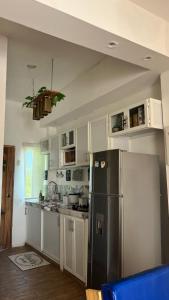 SinchalCerro Beach的厨房配有不锈钢冰箱和白色橱柜