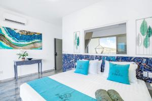 Koolbaaicondostmaarten by the sea的一间卧室配有一张带蓝色和白色枕头的床