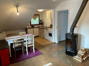 梅舍德Wohnung in idyllischem Örtchen的厨房配有桌子和燃木炉。