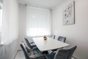 斯拉沃尼亚布罗德Apartman STRONG的白色的用餐室配有白色的桌椅