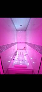 布隆Bron centre appartement meublé avec jacuzzi的大型浴缸内有粉红色的灯光