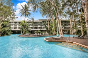 棕榈湾Hotel Drift 3205的一个带椅子和棕榈树的游泳池的度假酒店