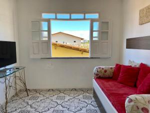 伊列乌斯Kalug - Guest House com 3 quartos em Condomínio na Praia dos Milionários的客厅设有红色的沙发和窗户。