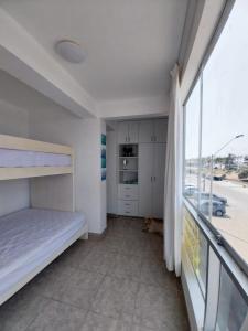 蓬塔赫尔莫萨Departamento en Punta Hermosa con vista al Mar的一间卧室设有一张床和一个大窗户