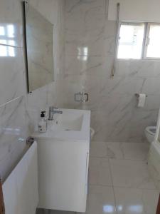 Casa Ricardo (16km de Coruña)的白色的浴室设有水槽和镜子
