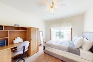 Secluded Ranch的一间卧室配有一张床、一张书桌和一个窗户。