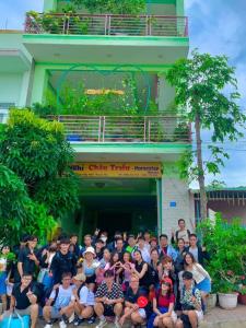 潘切Homestay Châu Triều - Phan Thiết的一群人站在一座建筑物前摆着一张照片