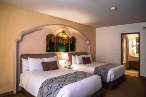 萨卡特卡斯萨卡特卡斯金塔实酒店的酒店客房,设有两张床和镜子