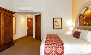 萨卡特卡斯萨卡特卡斯金塔实酒店的一间酒店客房,设有一张大床和一扇门