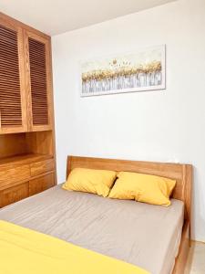 河内Azalea Apartment的卧室内的一张带黄色枕头的床