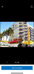 卡贝德卢Hotel Victory flat的棕榈树和鲜花的建筑的照片