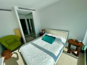 墨尔本Yarra Accommodation的一间卧室配有一张床和一把绿色椅子
