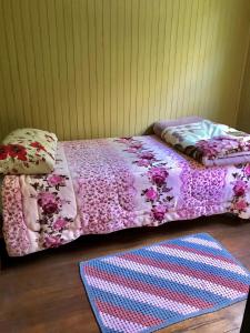 卡内拉Refúgio Linda Vista的一张带粉红色棉被和地毯的床
