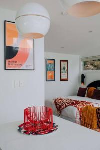 特里格尔Retro Retreat - by Coast Hosting的一间卧室配有红色椅子和一张床
