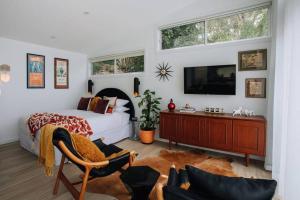 特里格尔Retro Retreat - by Coast Hosting的一间卧室配有一张床,墙上配有电视