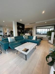 金斯顿Lakeview Luxe - EV charger, Pool, Gym, Location +的客厅配有蓝色的沙发和桌子