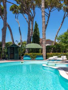 马尔米堡La Serena Hotel FDM的一个带椅子和树木的游泳池