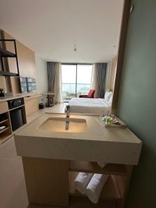 Miếu ÔngThe Arena Cam Ranh Resort all Luxury Service的一间带水槽的浴室和一张位于客房内的床