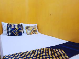 外南梦SPOT ON 92857 Kos Haji Jakfar Syariah的一张白色的床,上面有蓝色和黄色的枕头