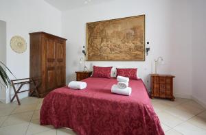 布拉恰诺LE CAMERE di VITTORIA的一间卧室配有红色的床和毛巾