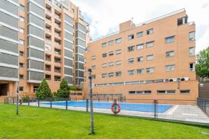 马德里Impresionante apartamento de 4 dormitorios 3 baños y 2 plazas de garaje的一座游泳池,位于一些高楼前