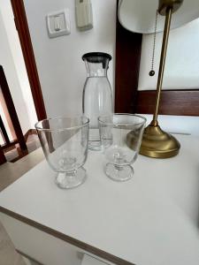 拉斯卡萨斯Casa La Asomada El Hierro的桌上有三只空眼镜,有灯