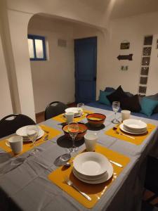 圣佩德罗·德·阿塔卡马Cabaña Pop的一张带黄色餐巾、盘子和酒杯的桌子